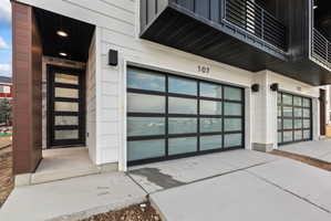 Entrance to property featuring an attached garage and driveway