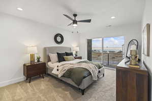 Bedroom featuring light carpet, a water view, a ceiling fan, access to outside, and recessed lighting