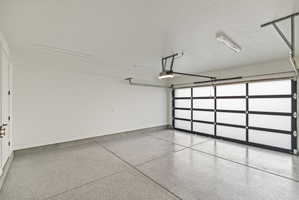 Garage featuring baseboards and a garage door opener