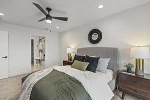 Bedroom featuring light colored carpet, a ceiling fan, ensuite bath, and recessed lighting