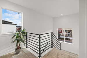 Stairs with carpet floors, plenty of natural light, and recessed lighting
