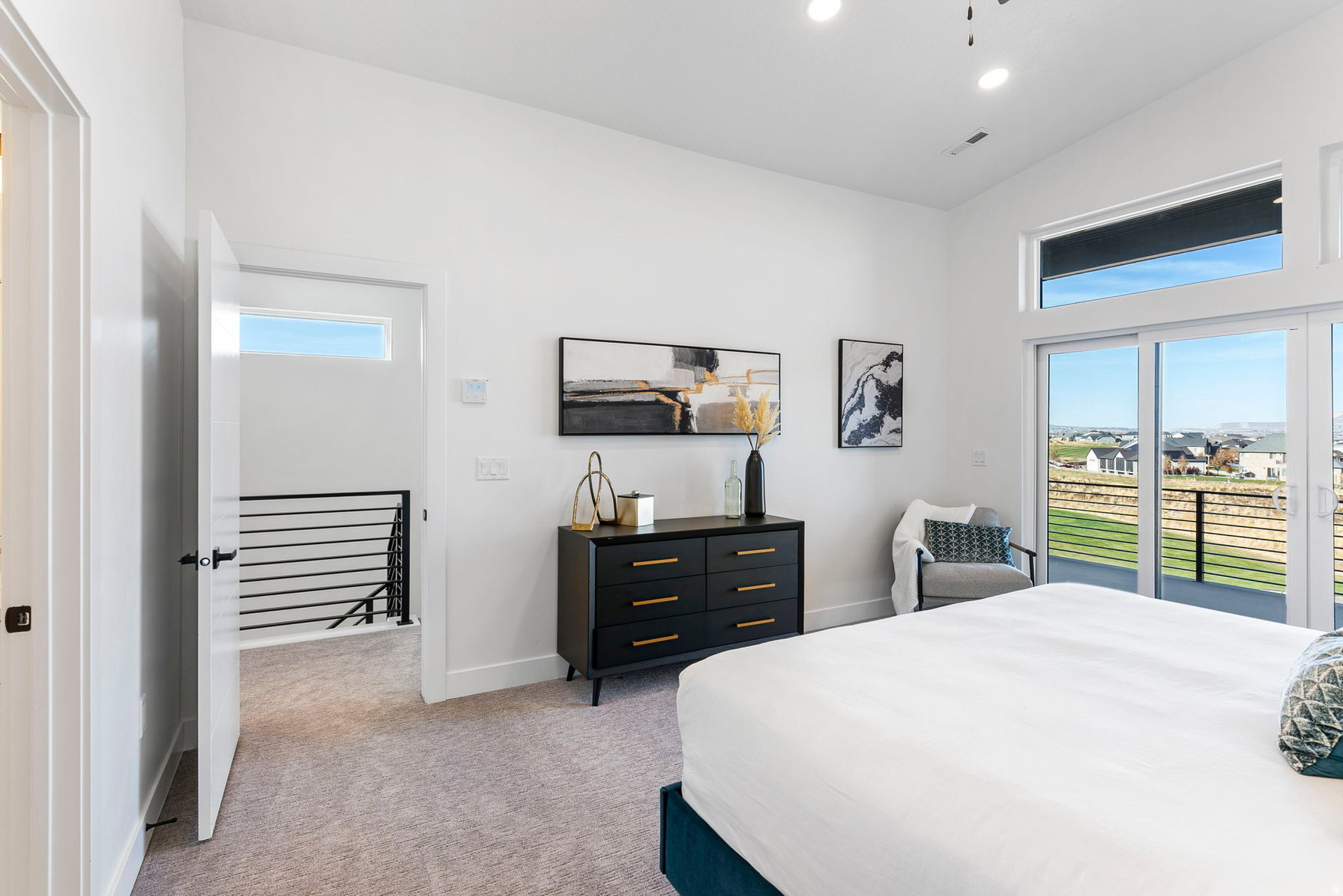 Spacious bedroom featuring light gray carpeting and white walls
