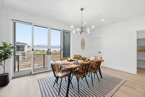 Dining room with a mountain view, light wood-type flooring, and a chandelier