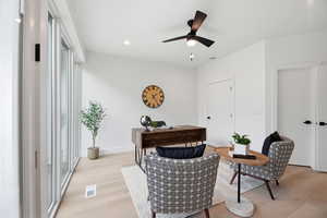 Sitting room with light wood-type flooring, a ceiling fan, an office area, and recessed lighting