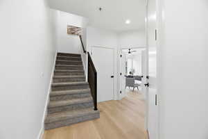 Staircase with wood finished floors, recessed lighting, and a ceiling fan