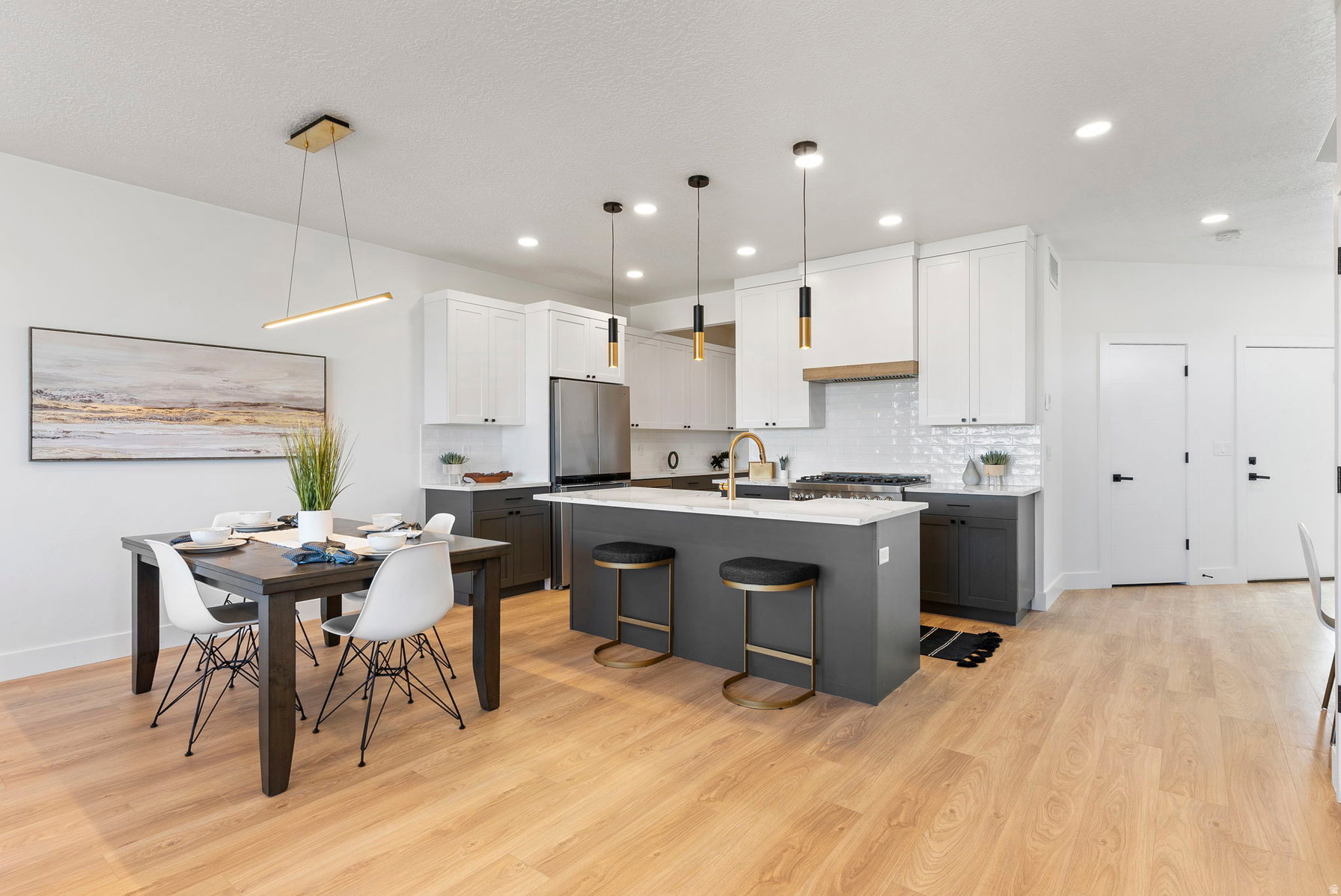 Modern kitchen and dining area featuring light wood-finish flooring