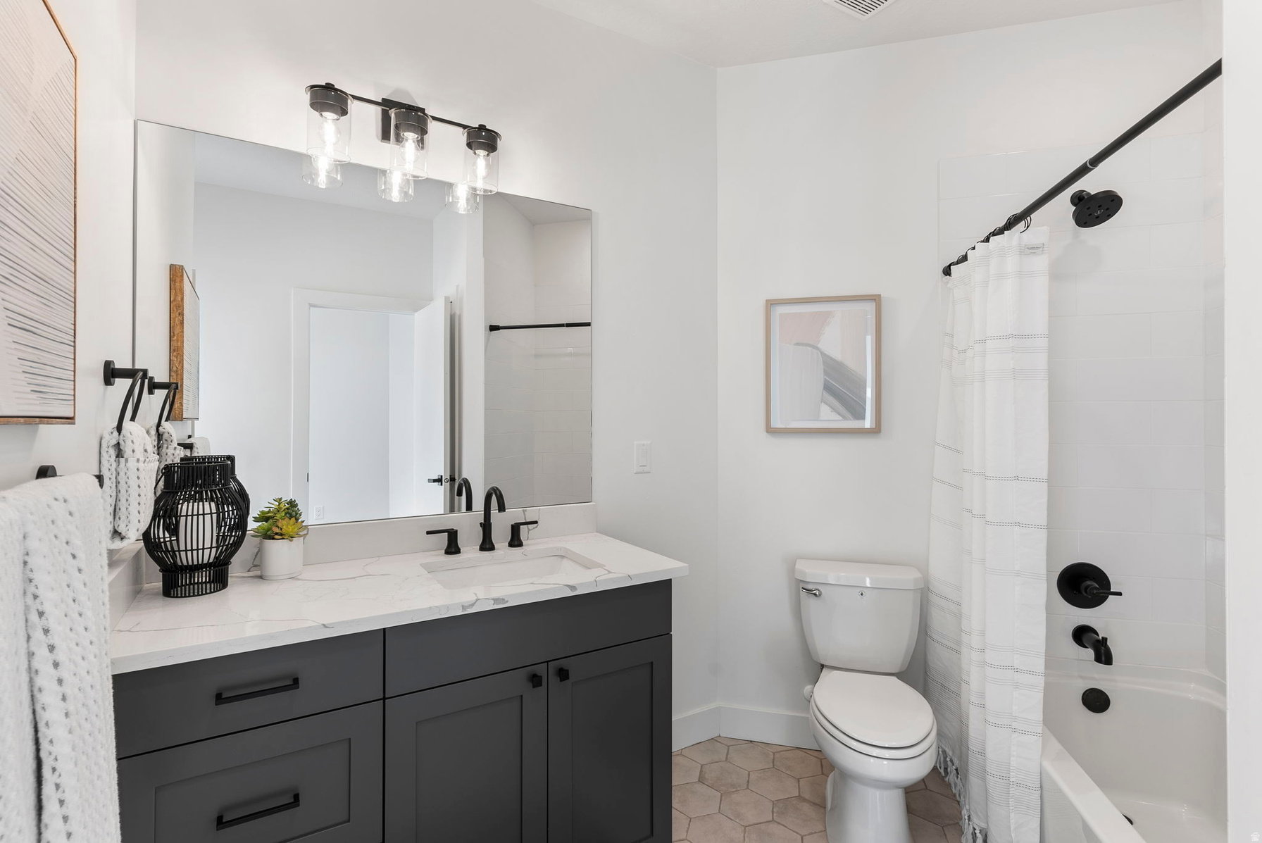 Bathroom featuring a dark gray vanity with a white countertop and integrated sink