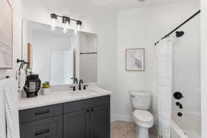 Bathroom featuring a dark gray vanity with a white countertop and integrated sink