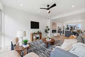 Living room featuring light wood finished floors, ceiling fan, and recessed lighting