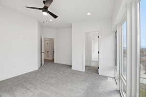 Unfurnished bedroom featuring light carpet, ceiling fan, and recessed lighting