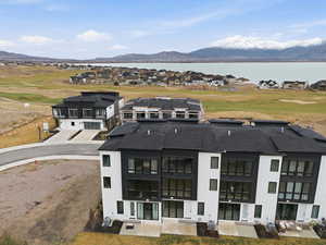 Aerial perspective of suburban area featuring a golf club and a water and mountain view