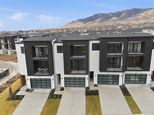 View of front of property featuring a residential view, an attached garage, and a mountain view