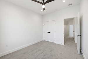 Unfurnished bedroom with light carpet, a ceiling fan, and a closet