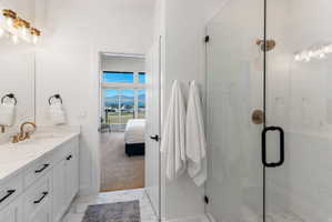 Modern bathroom featuring a glass-enclosed shower with a brushed brass shower head and black hardware