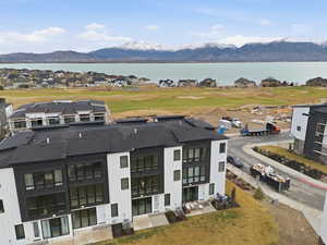 Aerial perspective of suburban area featuring a golf course and a water and mountain view
