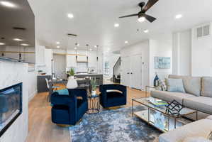 Open-concept living area featuring wood-finish flooring, recessed lighting, and a contemporary ceiling fan
