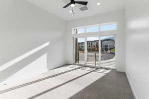 Room featuring a full glass sliding door, upper transom windows, recessed lighting, and a ceiling fan