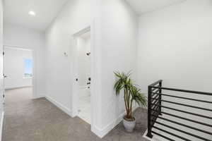 Hall with light carpet and vaulted ceiling