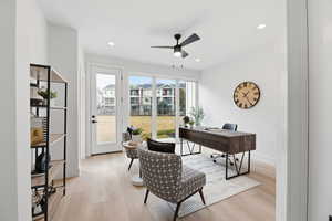 Office space featuring light wood finished floors, a ceiling fan, and recessed lighting