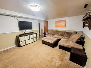 Living area featuring light carpet and baseboards