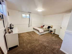 Bedroom with baseboards and dark carpet