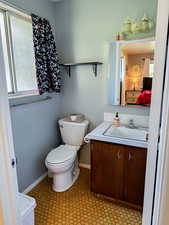 Half bath with vanity, connected bathroom, and light floors