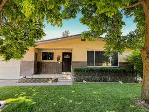 View of front of house with covered porch, brick siding, and stucco siding
