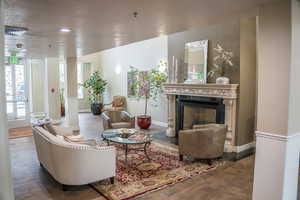 Living room featuring wood finished floors, a premium fireplace, and recessed lighting