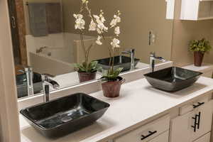 Bathroom featuring double vanity and a garden tub