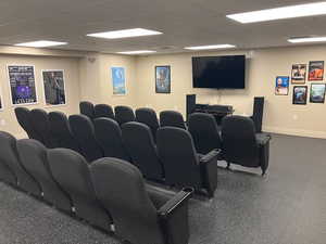 Home theater room with a paneled ceiling and baseboards
