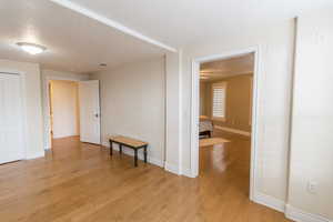 Spare room with a textured ceiling and light wood-style floors