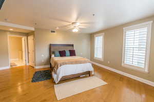 Bedroom with light wood-type flooring, ceiling fan, and a textured ceiling