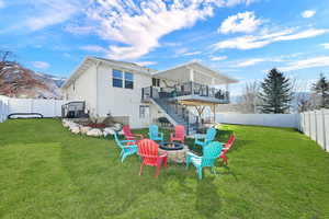 Rear view of house with a patio, a fire pit, a deck with mountain view, and a fenced backyard
