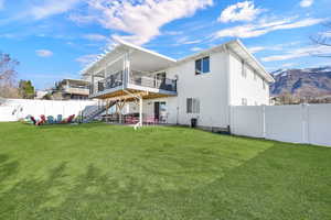 Rear view of property featuring a patio, a deck with mountain view, a fenced backyard, and a gate