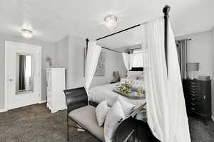 Bedroom featuring dark carpet and a chandelier