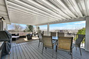 Wooden terrace featuring an outdoor living / dining area and a grill