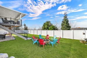 Fenced backyard with a patio area, a fire pit, and a deck