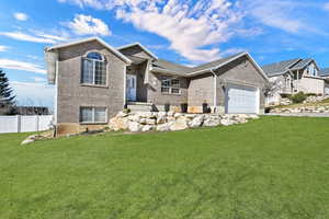 View of front of house featuring a garage, brick siding, and driveway