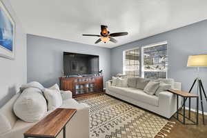 Living room featuring baseboards and ceiling fan