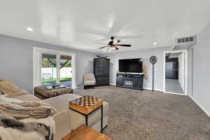 Living area with carpet flooring, a ceiling fan, recessed lighting, and a textured ceiling