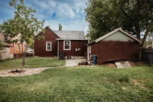 Back of house with a fire pit, a patio, roof with shingles, and detached garage