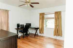Bedroom 2 with light wood finished floors and a ceiling fan