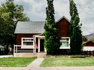 Cute bungalow with a shingled roof and a front porch