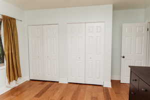 Bedroom 2 with multiple closets and light wood-style floors