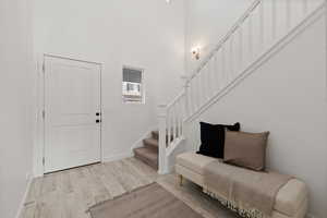 Entryway featuring light LVP flooring and a high ceiling