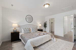 Primary bedroom featuring carpet flooring, light paint and walk-in closet