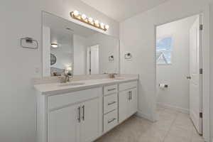 Detailed view of primary bathroom vanity with dual sinks and quartz countertops