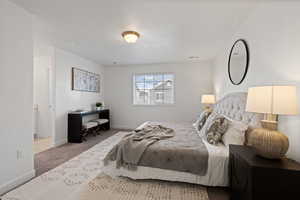 Primary bedroom featuring carpet flooring, light paint and ensuite bathroom