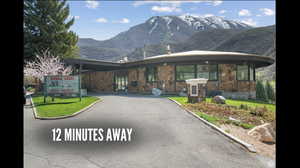 View of front facade featuring a mountain view, stone siding, and a front lawn