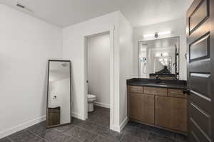 Full bathroom with vanity and a textured ceiling